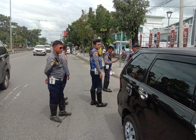 Petugas Dishub Kota Padang menertibkan kendaraan yang parkir sembarangan di Jalan Khatib Sulaiman, Senin (13/1).