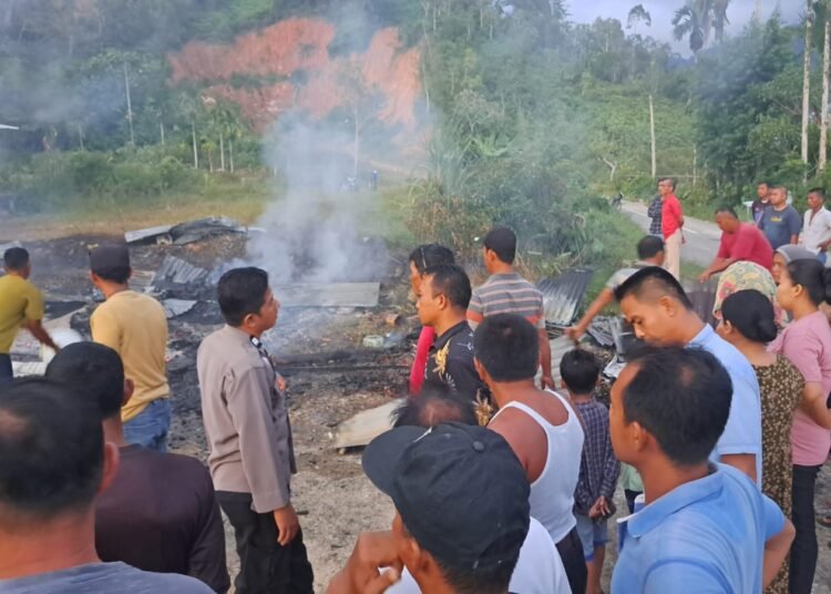 Warga membersihkan puing-puing rumah kayu di Cumateh, Kampung Simaung, Nagari Duku, Kecamatan Tarusan, Pesisir Selatan, yang terbakar pada Rabu (29/1/2025) pukul 18.10. IST.