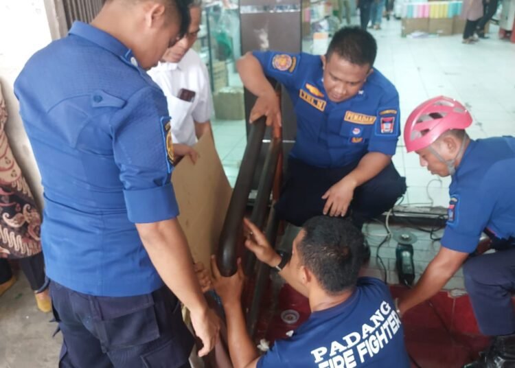 Petugas Damkar Padang berhasil menyelamatkan Ragil (4), bocah yang tangannya terjepit dalam pipa besi pegangan tangga di Pasar Raya Fase 1 pada Jumat (7/2) sore. IST