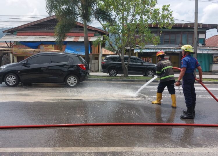 Petugas Damkar Padang menyiram debu di jalan Lubuk  Begalung (Lubeg)—Pasar Raya Indarung pada Selasa (25/2). Foto: IST