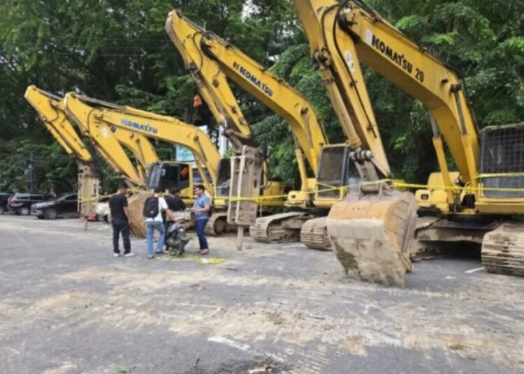 Empat alat berat barang bukti kasus dugaan tamnbang ilegal diletakkan di depan Kantor Polresta Padang, di Jalan M. Yamin, tepatnya di depan Ruang Terbuka Hijau Imam Bonjol Padang.