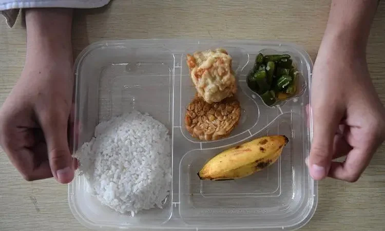 Siswa menunjukkan paket makan siang dalam pelaksanaan Program Makan Bergizi Gratis (MBG) di SD Negeri 25 Palembang, Sumatera Selatan, Senin (06/01). Foto: Antara