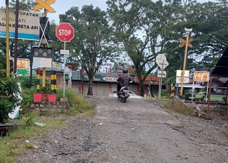 Seorang pengendara sepeda motor melewati perlintasan kereta api tanpa palang pintu di Korong Simpang Sungai Pinang, Nagari Kasang, Kecamatan Batang Anai, Padang Pariaman, Sabtu (12/4). Foto: Herru Iriawan/Kabarminang.com