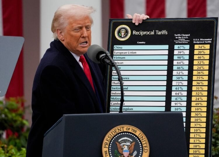 Presiden AS Donal Trump menunjukkan perintah eksekutif yang telah ditandatangani saat pengumuman tarif. (foto: Jim Lo Scalo/EPA/Bloomberg)