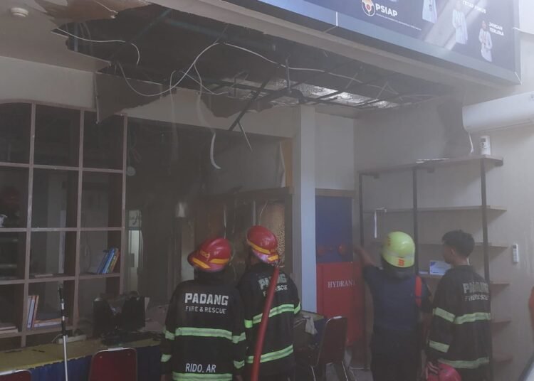 Petugas Damkar Padang memadamkan api di salah satu ruangan Kantor Pelayanan Pajak (KPP) Pratama Padang, Minggu (20/4)
