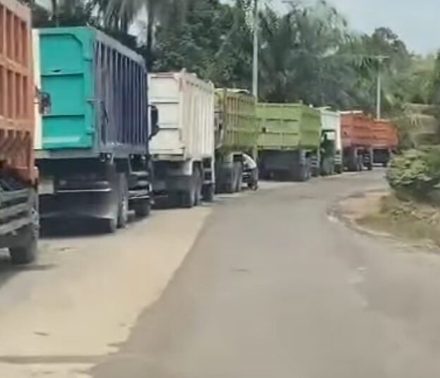 Belasan mobil dump tronton memakan bahu jalan saat melakukan antrian angkutan Tambang Galian C di Nagari Sungai Kambut Kabupaten Dharmasraya.