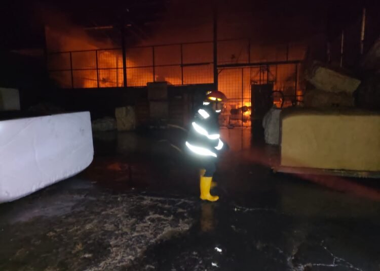 Petugas memadamkan api gudang penyimpanan spring bed di Padang pada Selasa (27/5) dini hari.