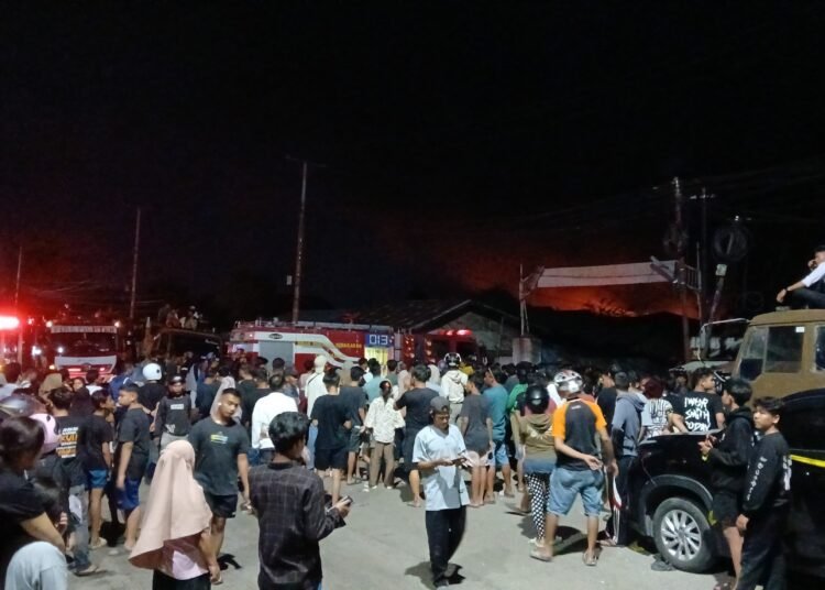 Lokasi kebakaran pabrik karet PT Teluk Luas di Padang masih dipadati warga, kebakaran masih terjadi. (foto: Sumbarkita.id)