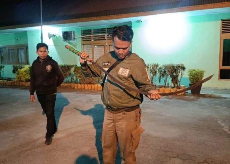 Petugas memperlihatkan senjata tajam yang disita saat pembubaran tawuran di kawasan Jalan Bypass, depan Pertamina Taruko, Kecamatan Kuranji, Kota Padang pada Sabtu dini hari (31/5/2025).