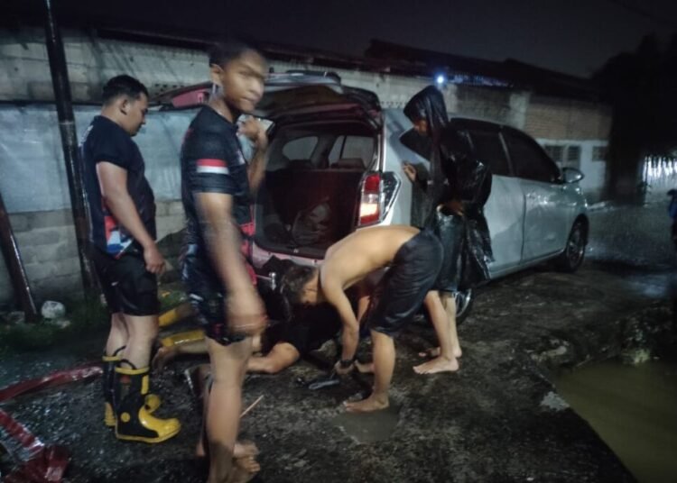 Sebuah mobil dievakuasi usai terperosok ke dalam parit akibat jalan tergenang air di kawasan Jundul, Kelurahan Rawang, Kecamatan Padang Selatan, Kota Padang, pada Senin malam (16/6/2025).