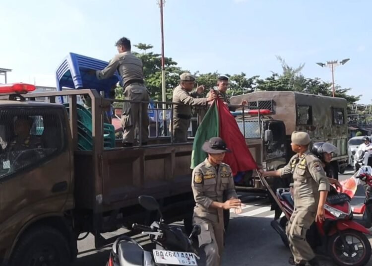 Satuan Polisi Pamong Praja (Satpol PP) Kota Padang menertibkan sejumlah Pedagang Kaki Lima (PKL) yang berjualan di kawasan Pantai Padang, tepatnya di depan Lapau Panjang Cimpago (LPC), Sabtu (14/6/2025).