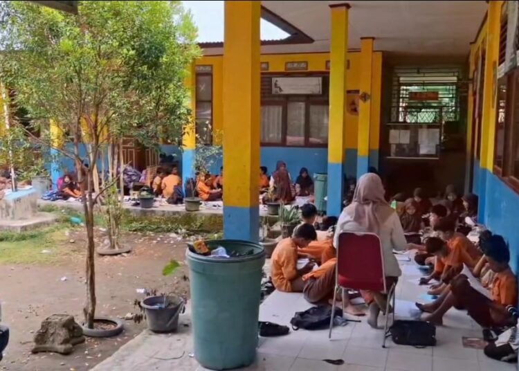 Murid SDN 05 Sungai Limau, Padang Pariaman, duduk di teras karena penjaga sekolah itu menggembok semua ruang kelas pada Kamis (24/7). Foto: IST