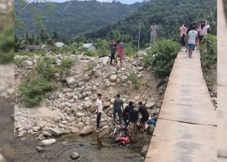 Sejumlah warga mengevakuasi dua warga yang terjatuh ke sungai dari jembatan darutat di Koto Rawang, Kecamatan IV Jurai, Pesisir Selatan, pada Minggu (20/7) sekitar pukul 12.00 WIB. Foto: IST