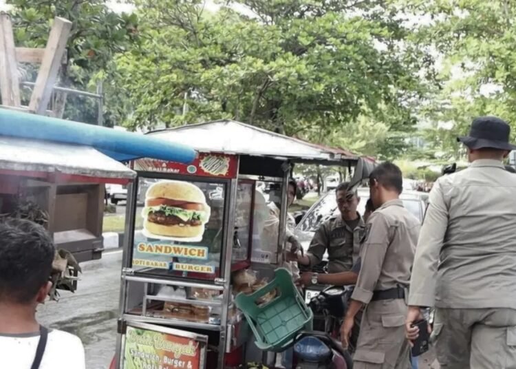 Petugas menertibkan sejumlah lapak di kawasan Pantai Padang. (foto: Satpol PP Kota Padang).