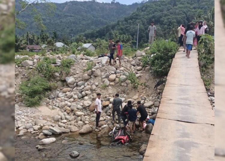 Sejumlah warga mengevakuasi dua warga yang terjatuh ke sungai dari jembatan darutat di Koto Rawang, Kecamatan IV Jurai, Pesisir Selatan, pada Minggu (20/7) sekitar pukul 12.00 WIB. Foto: IST
