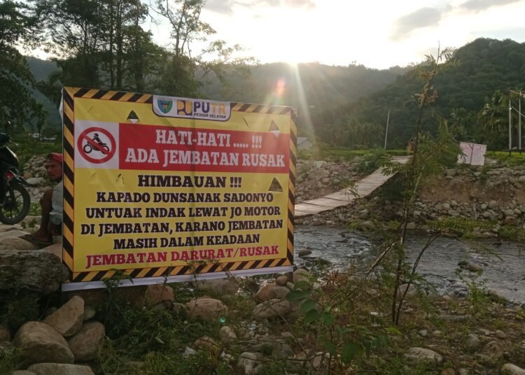 Dinas Pekerjaan Umum dan Penataan Ruang (PUTR) Pesisir Selatan memasang spanduk peringatan dan imbauan di samping kedua pintu masuk jembatan darurat Nagari Koto Rawang, Kecamatan IV Jurai, pada Senin (21/7). Foto: IST