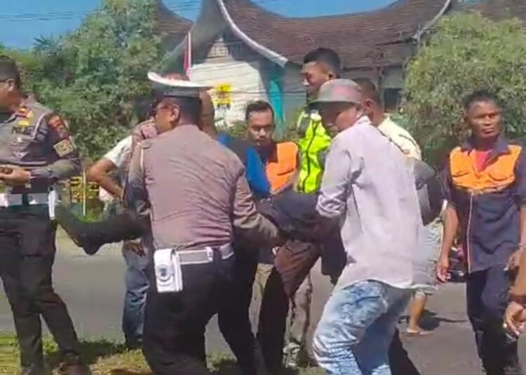 Polisi dan warga evakuasi pria tergeletak di pinggir jalan di Padang, Selasa (8/7).