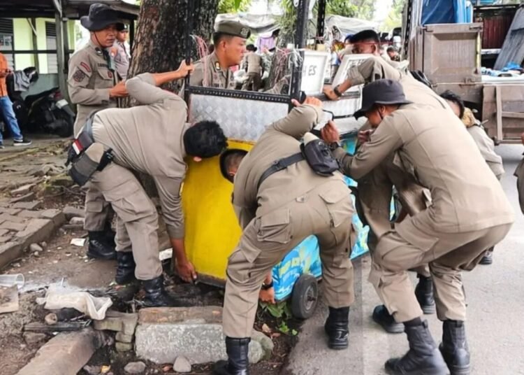 Petugas Satpol PP Padang bersama tim gabungan menertibkan lapak pedagang kaki lima (PKL) yang berjualan di atas fasilitas umum, Sabtu (23/8/2025) pagi.
