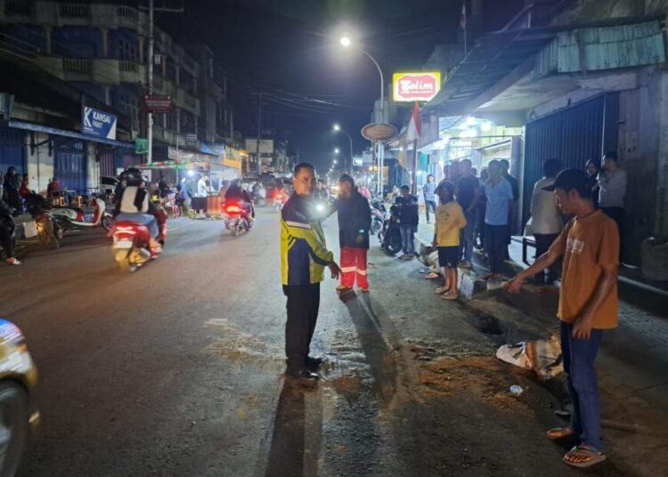 Polisi menunjukkan lokasi kecelakaan di Jalan Ahmad Yani, Keurahan Nunang Daya Bangun, Kecamatan Payakumbuh Barat, Payakumbuh, Rabu (13/8) sekitar pukul 20.30 WIB. Foto: Polres Payakumbuh
