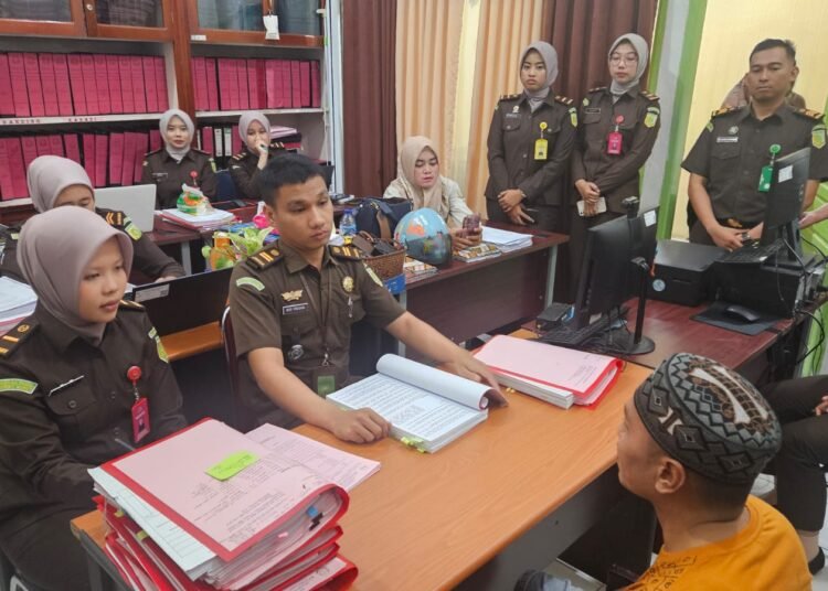 Polisi menyerahkan tersangka pemutilasi dan pemakan daging manusia di Pesisir Selatan ke kejaksaan negeri setempat pada Selasa (14/8). Foto: Kejaksaan Negeri Pesisir Selatan