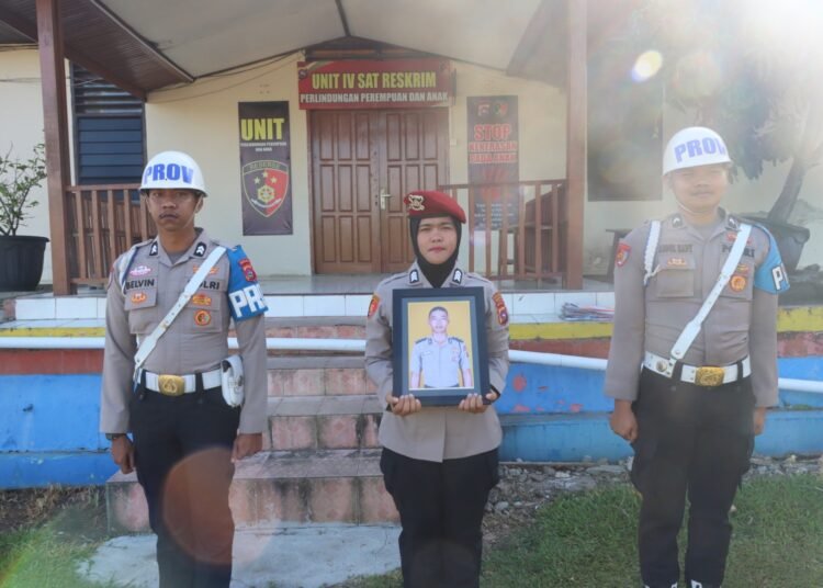 Polwan memegang foto Briptu YP, polisi yang dipecat dalam upacara Pemberhentian Tidak Dengan Hormat di lapangan apel kantor polres pada Senin (25/8). Foto: Polres Tanah Datar