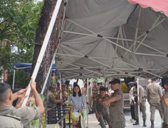Petugas Satpol PP menertibkan pedagang kaki lima (PKL) yang menggunakan fasilitas umum sebagai tempat berjualan di sepanjang Jalan Jhoni Anwar, Kelurahan Lapai, Kecamatan Nanggalo, Jumat (19/9/2025).