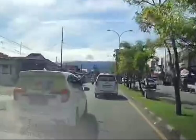Seorang pengemudi mobil berlogo Maxim mengacungkan pisau kepada pengendara lain di kawasan Simpang Haru, Kota Padang, Senin (15/9).