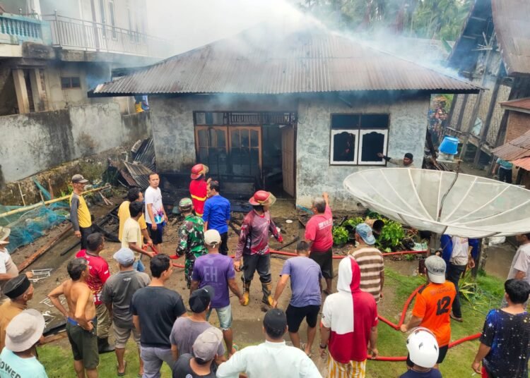 Petugas Damkar dibantu warga memadamkan rumah terbakar di Jorong Lingkuang, Nagari Tanjung Barulak, Kecamatan Tanjung Emas, Kabupaten Tanah Datar, Sabtu (27/9/2025). IST