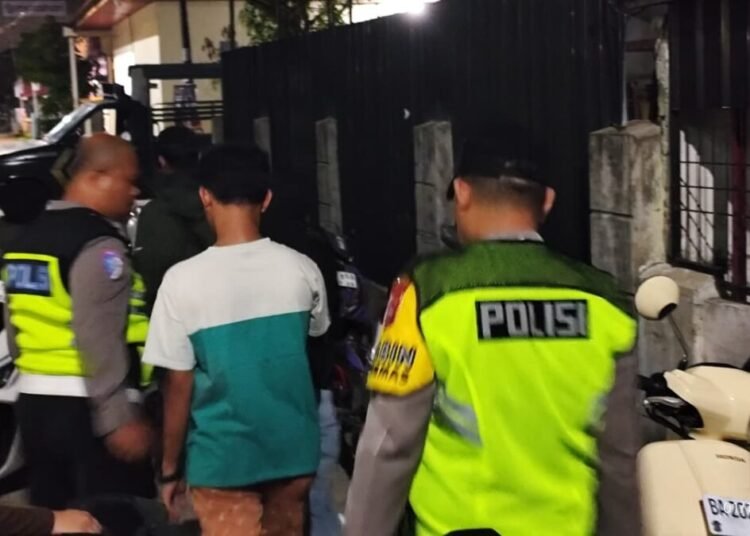 Polisi membawa mahasiswa yang digerebek warga di dalam kamar kos Jalan Cendrawasih 1, Kelurahan Air Tawar Barat, Kecamatan Padang Utara, Kota Padang, pada Rabu (1/10) sekitar pukul 00.30 WIB. Foto: Polsek Padang Utara