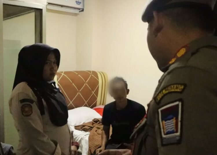 Petugas Satpol PP Padang mengamankan pasangan tak resmi saat razia di penginapan, Selasa (4/11/2025).