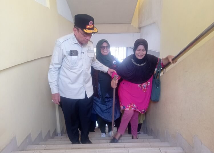 Wakil Wali Kota Padang Maigus Nasir membantu warga naik ke shelter SMP Negeri 25 Padang saat simulasi evakuasi gempa dan tsunami, Rabu (5/11/2025).