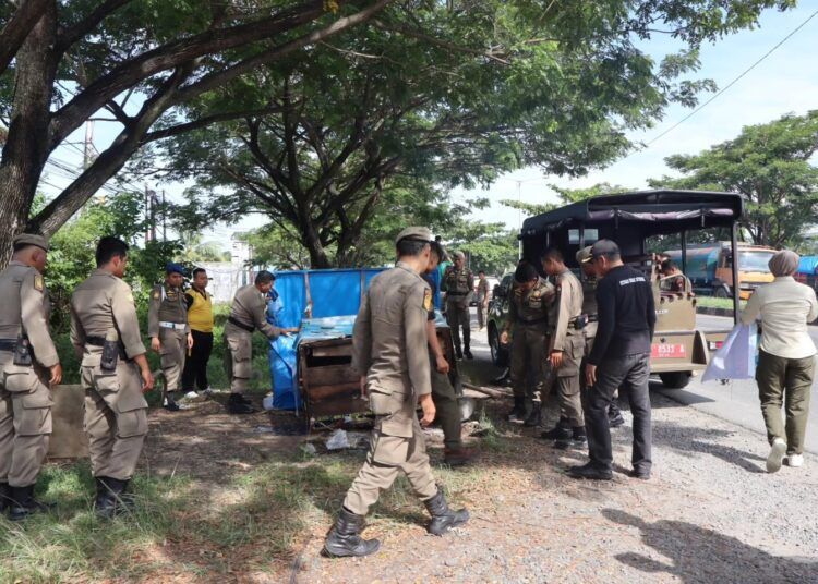 Petugas Satpol PP Padang bersama Tim Satuan Kerjasama Keamanan dan Ketertiban (SK4) menertibkan sejumlah lapak pedagang kaki lima (PKL) yang masih membandel berjualan di fasilitas umum sepanjang Jalur By Pass hingga kawasan Lubuk Begalung (Lubeg), Sabtu (15/11/2025).