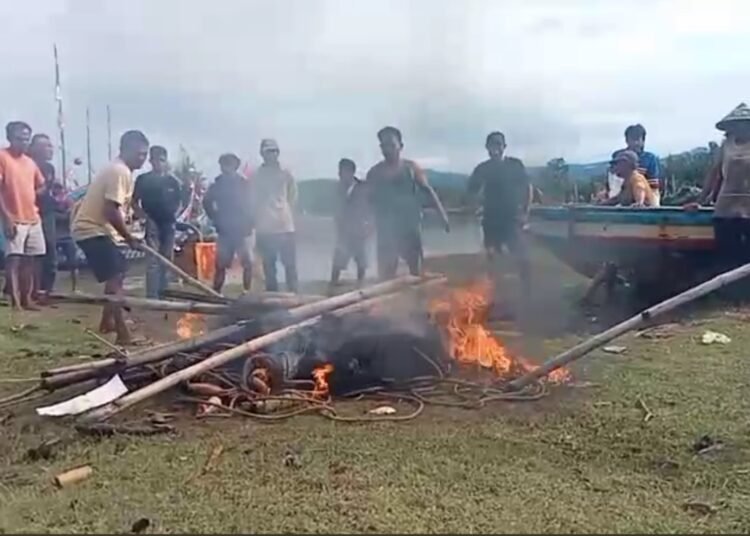 Sejumlah nelayan tradisional di Nagari Muara Kandis Pungasan, Kecamatan Linggo Sari Baganti, Pesisir Selatan, membakar pukat harimau mini setelah bentrok antarnelayan di laut pada Jumat (21/11). Foto: IST