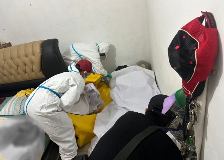 Proses evakuasi mayat pria usia 65 tahun yang ditemukan meninggal dunia dalam keadaan membusuk di rumahnya di Dusun Cabe, Jorong Sungai Salak, Nagari Koto Tangah, Kecamatan Tanjung Emas, Tanah Datar, pada Sabtu (22/11/2025) sekitar pukul 14.30 WIB. Foto: Polsek Tanjung Emas