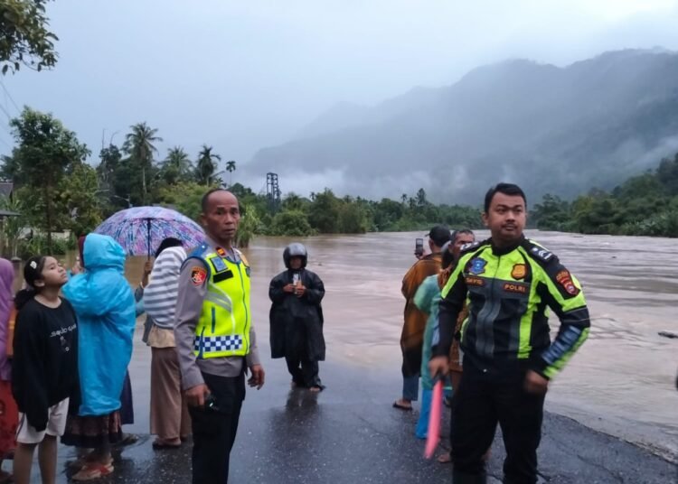 Jalan lintas Padang–Bengkulu terendam banjir, tepatnya di Nagari Duku, Kecamatan Koto XI Tarusan, Kabupaten Pesisir Selatan, pada Senin (24/11/2025). Foto: Polsek Koto XI Tarusan