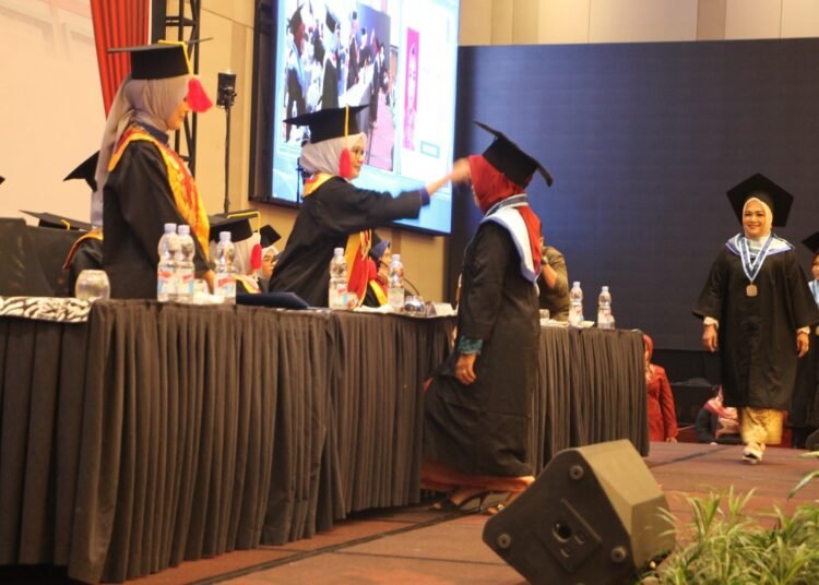 Rektor Universitas Alifah Padang, Dr. Fanny Ayudia, memindahkan jambul wisudawan pada Wisuda Tahap II Tahun 2025 di The ZHM Premiere Hotel and Convention Padang, Selasa (11/11/2025).