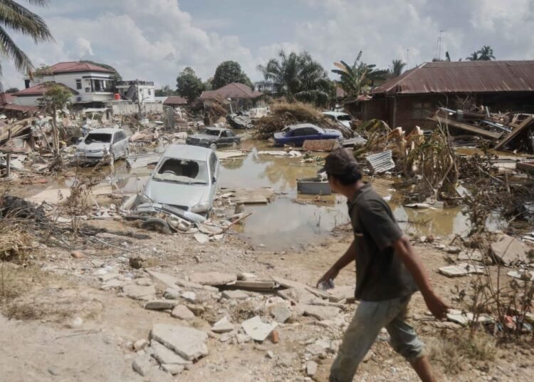Puing-puing dan kendaraan berserakan usai banjir bandang menerjang Aceh Tamiang. (AP Photo/Binsar Bakkar).
