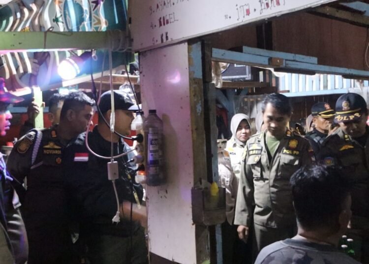 Satpol PP Padang menertibkan sebuah warung kopi yang menjual minuman beralkohol secara ilegal di kawasan Air Camar, Kecamatan Padang Timur, pada Rabu (10/12/2025) malam. Foto: Satpol PP Padang