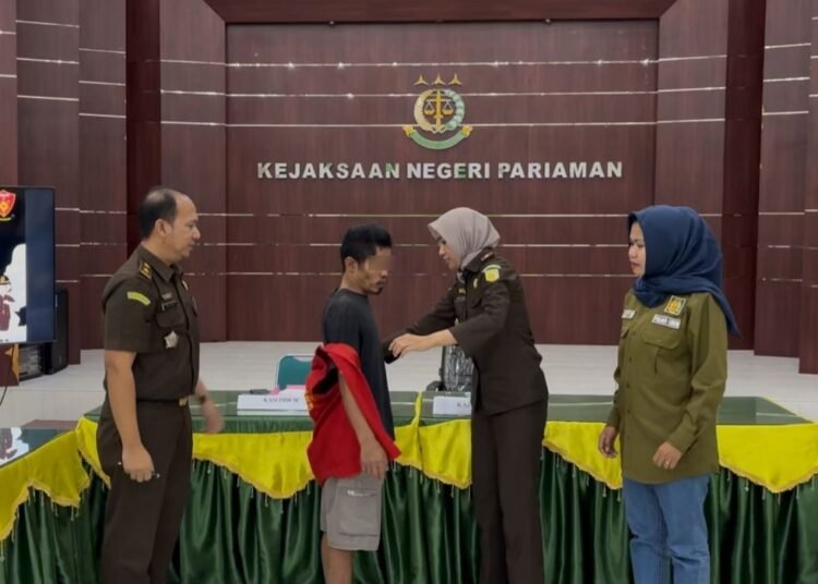 Kepala Kejari Pariaman, Anggia Yusran, menanggalkan rompi tahanan tersangka pencuri sepeda motor di aula Kejari Pariaman pada Rabu (17/12) pertanda berakhirnya kasus tersangka dengan pendekatan keadilan restoratif. Foto: Kejari Pariaman