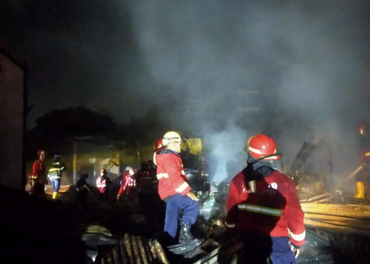 Petugas pemadam memadamkan api yang membakar sebuah rumah dan tiga toko di Simpang Pasar Bandar Buat Nomor 30, Kelurahan Bandar Buat, Kecamatan Lubuk Kilangan, pada Sabtu (27/12) malam. Foto: Dinas Damkar Padang