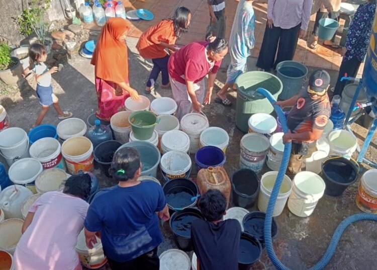 Warga mengantre air bersih dari tandon bantuan BPBD Kota Padang di Kecamatan Kuranji, akibat sumur mengering pascabanjir bandang November 2025.