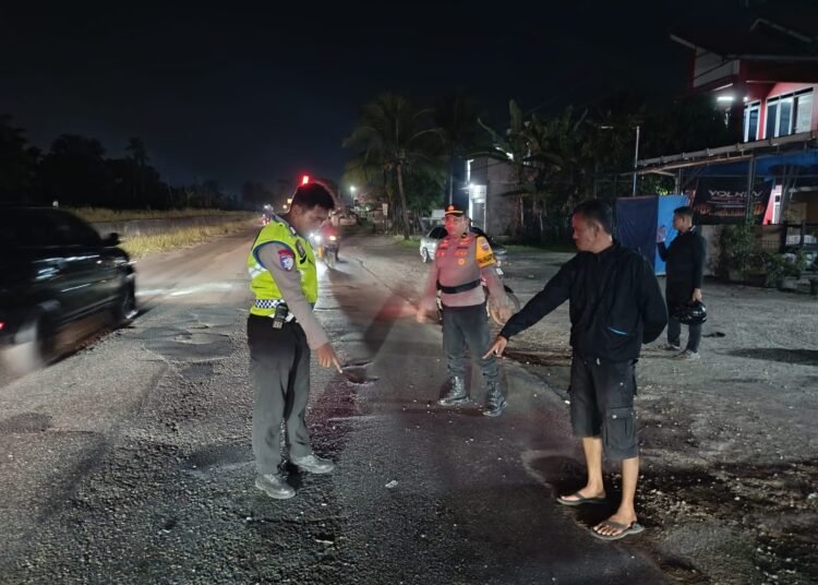 Polisi melakukan olah tempat kejadian perkara (TKP) kecelakaan dua sepeda motor di Jalan Raya Padang–Bukittinggi, tepatnya di Korong Kabun, Nagari Kasang, Kecamatan Batang Anai, Kabupaten Padang Pariaman, Sabtu (31/1/2026) sekitar pukul 20.00 WIB. Foto: Polres Padang Pariaman