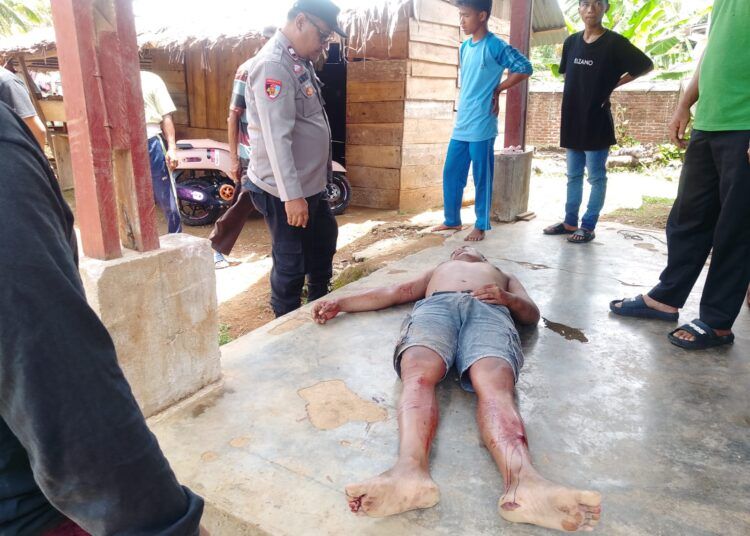 Seorang warga terkapar di teras rumanya setelah dianiaya di rumahnya di Kampung Sungai Sirah Mudik, Nagari Sungai Sirah Air Haji, Kecamatan Linggo Sari Baganti, Pesisir Selatan, oleh sekitar 15 orang pada Sabtu (14/2/2026) pagi. Foto: Polsek Linggo Sari Baganti
