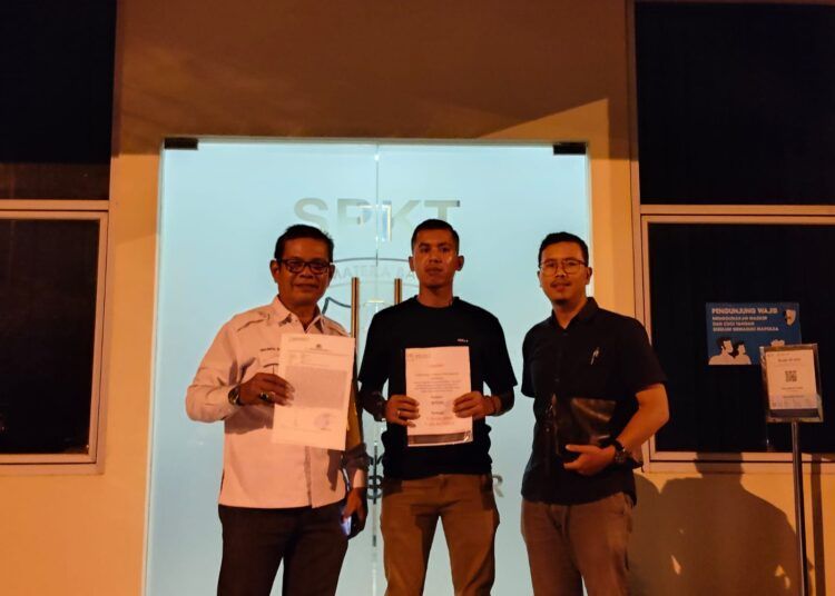 Afrizal (tengah) didampingi pengacaranya, Mardefni Zainir (kiri), dan rekannya (kanan) berfoto di depan Unit SPKT Polda Sumbar setelah melaporkan pengembang perumahan pada Kamis (26/2/2026).