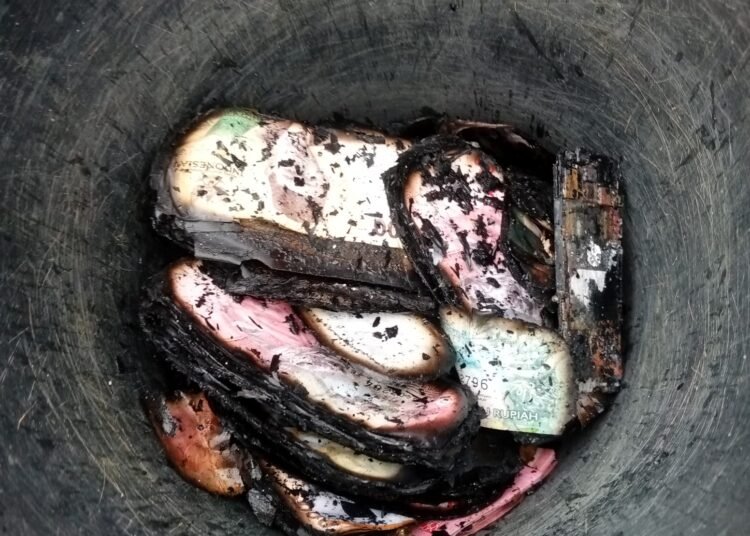 Uang tunai milik korban yang diduga merupakan dana THR terlihat hangus terbakar usai kebakaran rumah di Painan Timur.