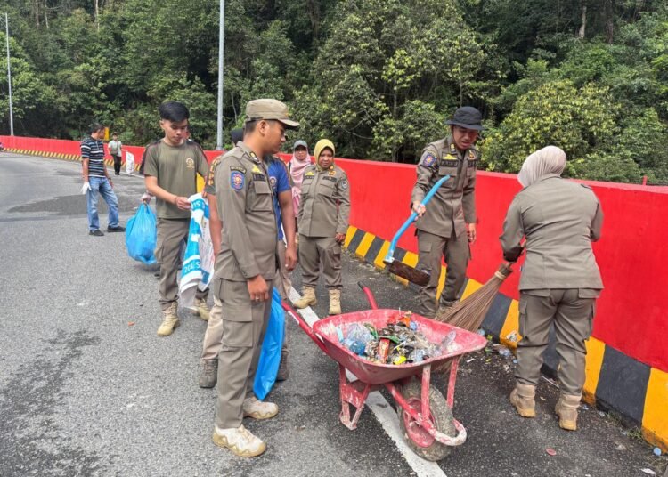 Petugas Satpol PP Limapuluh Kota membersihkan sampah di kawasan Jembatan Layang Kelok 9 pada Selasa (31/3/2026). Foto: Satpol PP Limapuluh Kota