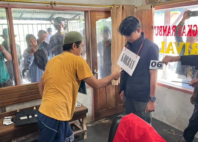 Petugas kepolisian Polres Solok memperagakan ulang adegan rekonstruksi kasus dugaan penganiayaan maut di Jorong Sungai Rotan, Nagari Cupak, Kecamatan Gunung Talang, Rabu (1/4/2026).