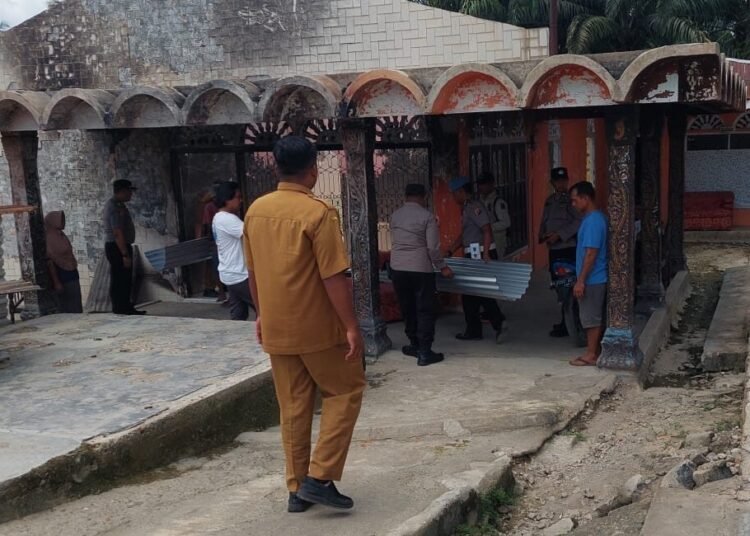 Di puing-puing sisa bangunan Halimah di Jorong Sungai Tambang II, Nagari Kunpar (Kunangan Parit Rantang), Kecamatan Kamang Baru, Kapolsek Kamang Baru, AKP Syafrinaldi, menyerahkan bantuan kapolres berupa lima kodi atap seng. Bantuan itu diterima oleh Halimah didampingi oleh sekretaris nagari setempat, Kunpar Elvandri, pada Selasa (28/4/2026). Foto: Polres Sijunjung