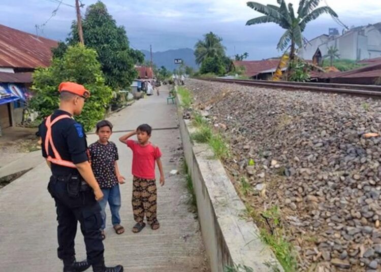 Polisi khusus kereta api berbicara dengan bocah dekat salah satu perlintasan sebidang di Padang. Foto: PT KAI Divre II Sumbar