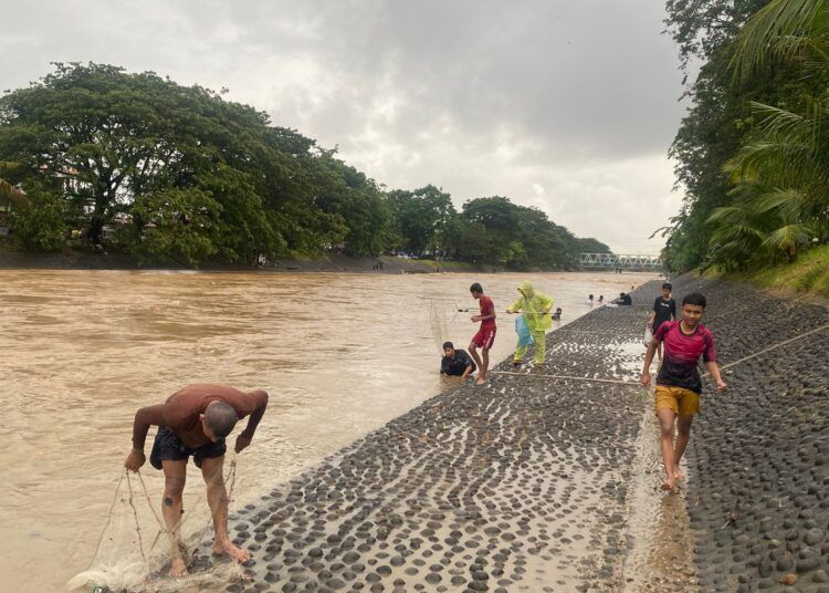 Sejumlah warga di Kota Padang memanfaatkan naiknya debit air Sungai Banda Bakali untuk menjala hingga memancing ikan pada Rabu (13/5/2026) sore. Foto: Rifi Fariadi Ridwan/Sumbarkita